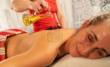 Photo for Woman in hammam or turkish bath getting oil massage at sap resort - Royalty Free Image