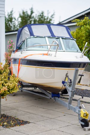 Photo for Small motorboat on trailer parked in driveway near house. High quality photo - Royalty Free Image