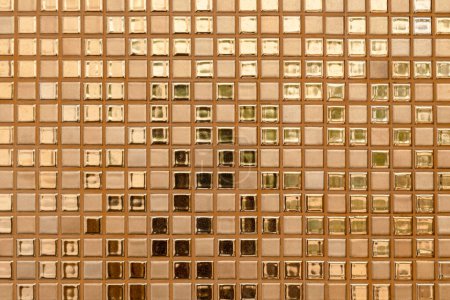 Foto de Close-up of golden-colored square glass tiles covering the bathroom wall texture as a background. - Imagen libre de derechos