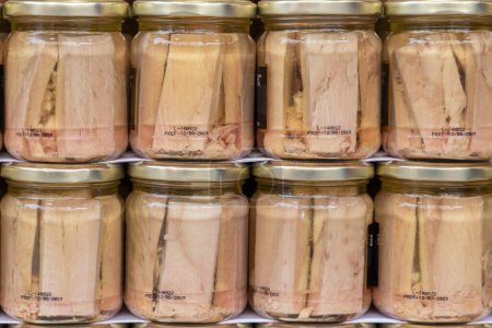 Photo for Close up in horizontal view of several glass jar with preserved fillets of white tuna. food preservation concept - Royalty Free Image