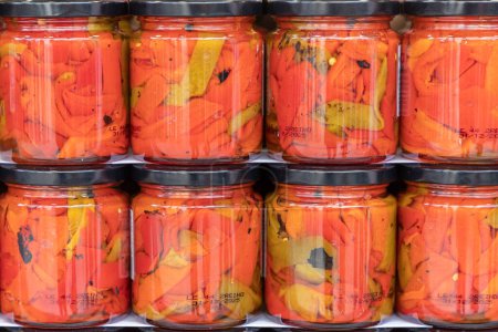 Photo for Close up in horizontal view of several glass jars with preserved red peppers. food preservation concept - Royalty Free Image