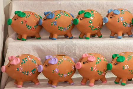 Photo for Horizontal view in close up of an expositor with some decorative piggy banks for sale as souvenir - Royalty Free Image