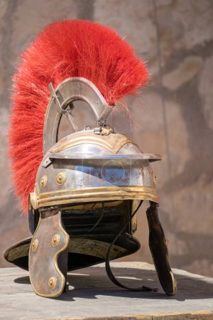 Foto de Vista vertical de un casco de centurión romano con penacho rojo: Un casco militar romano, usado por legiones del antiguo Imperio Romano. Símbolo de poder y fuerza - Imagen libre de derechos