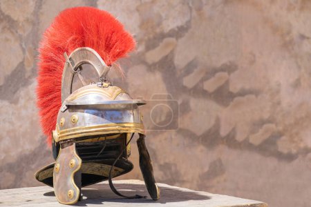 Foto de Vista horizontal de un casco de centurión romano con penacho rojo: Un casco militar romano, usado por legiones del antiguo Imperio Romano. Símbolo de poder y fuerza - Imagen libre de derechos