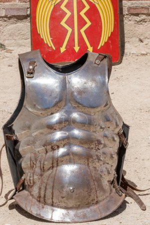 Téléchargez les photos : Vue verticale d'un ancien soldat de l'empire romain cuirasse "Lorica Musculata" et bouclier rectangulaire de couleur rouge "scutum augusta" en arrière-plan - en image libre de droit