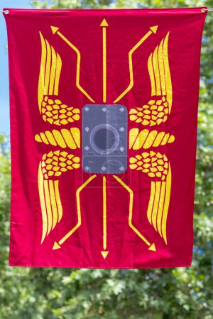 Téléchargez les photos : Vue verticale d'une bannière de couleur rouge avec le symbole d'un ancien bouclier de l'empire romain - en image libre de droit