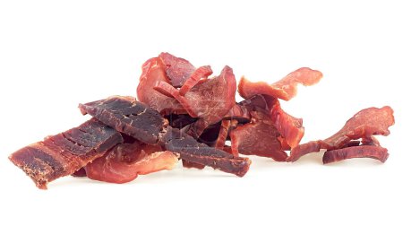 Portion de viande tranchée et séchée isolée sur fond blanc. Pile de morceaux de porc saccadés.