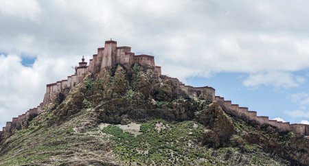 Foto de Gyantse Dzong o fortaleza Gyantse es uno de los dzongs mejor conservados en el Tíbet, encaramado en lo alto de la ciudad de Gyantse en un enorme espolón de roca marrón gris - Tíbet - Imagen libre de derechos