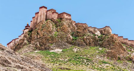 Foto de Gyantse Dzong o fortaleza Gyantse es uno de los dzongs mejor conservados en el Tíbet, encaramado en lo alto de la ciudad de Gyantse en un enorme espolón de roca marrón gris - Tíbet - Imagen libre de derechos