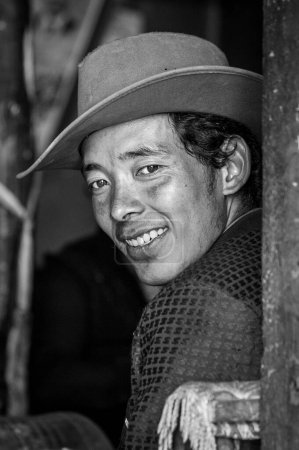 Foto de GYANTSE, TIBET, CHINA - 21 de agosto de 2018: Hombre tibetano indefinido con sombrero en una tienda en Gyantse, Gyantse Country, Shigatse, Tibet - Imagen libre de derechos