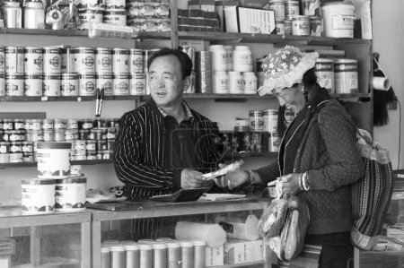 Photo for GYANTSE, TIBET, CHINA - AUGUST, 21 2018: Unidentified tibetan man and woman in a shop in Gyantse, Gyantse Country, Shigatse, Tibet - Royalty Free Image