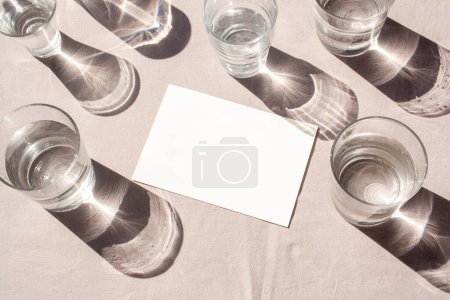 Foto de Espacio vacío en blanco y vasos con agua y sombras contrastantes. Tendencia de moda. Día soleado. Burla. - Imagen libre de derechos