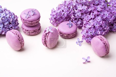 Photo for Lilac macarons and lilac flowers. Delicious dessert on a white table - Royalty Free Image