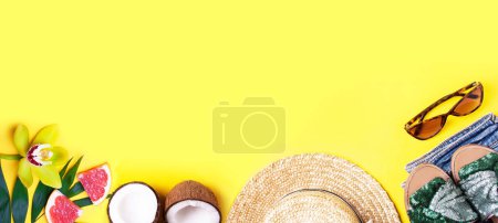 Téléchargez les photos : Bannière d'été avec chapeau de paille, noix de coco, feuilles de palmier, orchidée et lunettes de soleil sur fond jaune. Style de pose plat - en image libre de droit