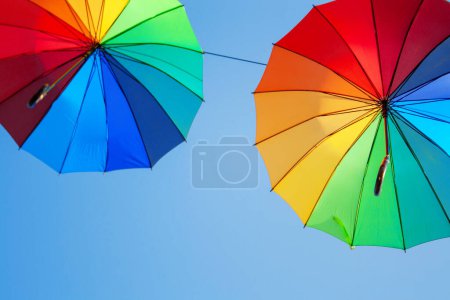 Téléchargez les photos : Deux parapluies multicolores contre le ciel bleu - en image libre de droit
