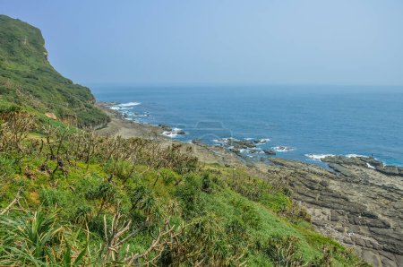 Téléchargez les photos : Montagne verte naturelle sur la plage côtière rocheuse avec de l'eau de mer bleue de Bitou Cape (Bitoujiao) dans le district de Ruifang de New Taipei City, Taiwan - en image libre de droit