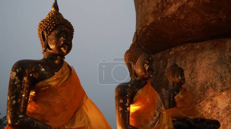 Photo for The three Buddha statues during sunset sitting on top of the mountain in Khao Khitchakut National Park located in Chanthaburi of Thailand - Royalty Free Image