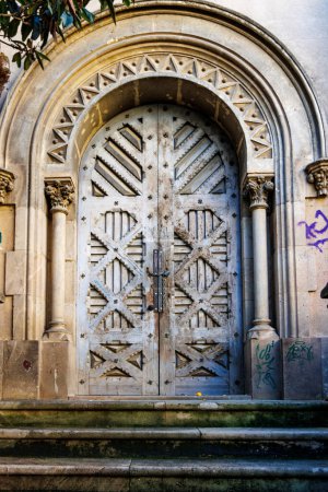Old ornate wooden door of a ruined church in El Raval, Barcelona, Catalonia, Spain, Europe
