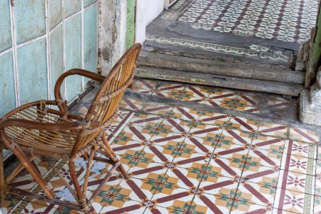 Old chair and pavement with old decorated ceramic tiles in the historical center of George Town, Penang, Malaysia, Asia