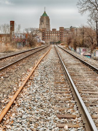 Téléchargez les photos : Railroad tracks in the Lincoln Park area of Detroit leads towards an office building in the Midtown area. - en image libre de droit