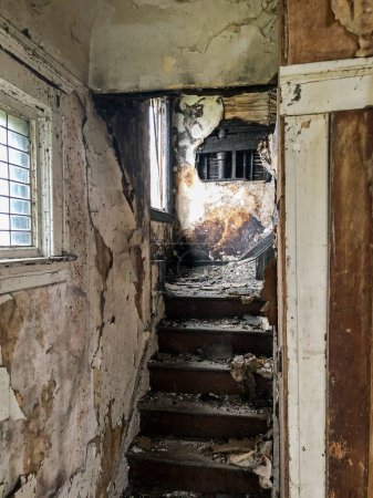 Photo for Stairs filled with dirt and debris lead upstairs inside an abandoned house in Highland Park. - Royalty Free Image