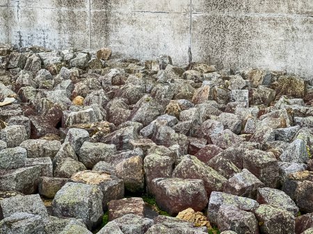 Photo for MAUTHAUSEN, AUSTRIA - DECEMBER 4, 2022: A pile of heavy rocks that is heaped up outside a concrete wall memorializes the slave labor from the quarry at the Mauthausen concentration camp in Austria. - Royalty Free Image