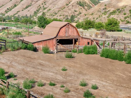 Téléchargez les photos : Une grange rouge rustique est située à côté de la rivière Lower Salmon près de Lucile, Idaho. - en image libre de droit