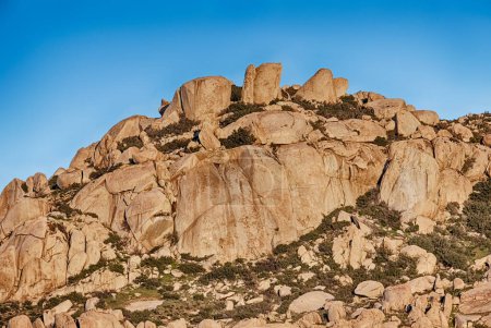 Foto de Enormes rocas de granito que se asemejan a las placas de un dinosaurio estegosaurio alinean la línea de una montaña en el desierto cerca de Tecate. - Imagen libre de derechos