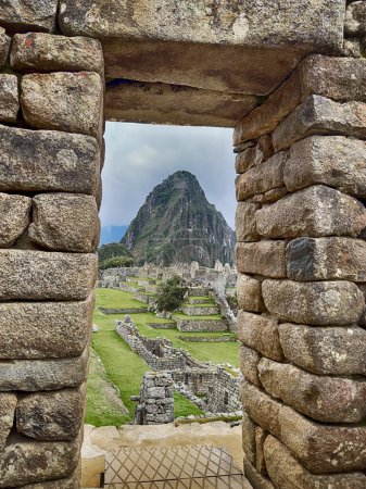 Téléchargez les photos : Une porte traditionnelle inca encadre certaines parties de Macchu Picchu et la plus petite montagne de Huayna Picchu. - en image libre de droit
