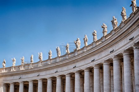 Fifteen saints line the top of the colonnade that encloses the main courtyard in front of the basilica of St. Peter in Rome.