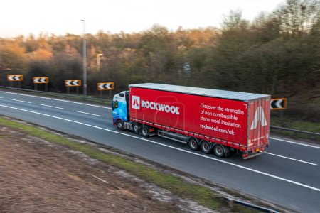 Téléchargez les photos : Watford, Royaume-Uni - 4 avril 2023 : Camion appartenant au fabricant de l'isolant Rockwool, circulant sur l'autoroute britannique M1. - en image libre de droit