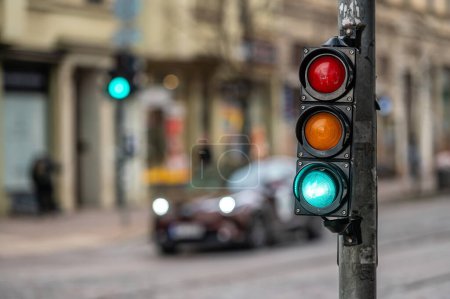 Foto de Visión borrosa del tráfico de la ciudad con semáforos, en primer plano un semáforo con luz verde - Imagen libre de derechos