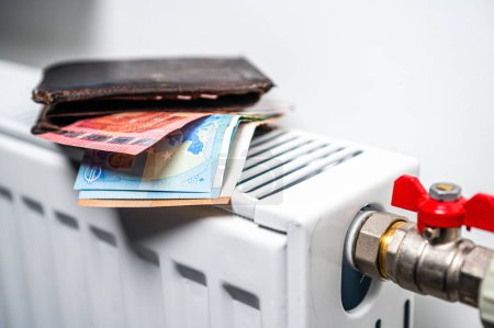 Foto de Wallet with euro banknotes on central heating radiator, concept of expensive heating costs, close-up - Imagen libre de derechos