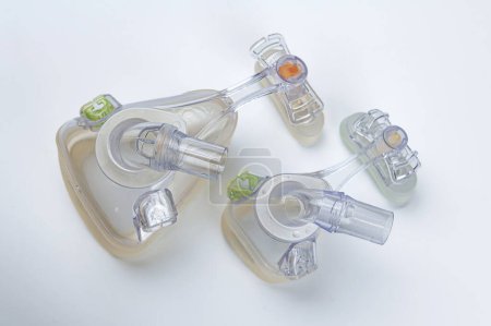 Foto de Máscaras médicas de cara completa y oxígeno nasal para pacientes con apnea obstructiva del sueño sobre fondo blanco. - Imagen libre de derechos