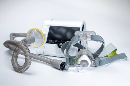 Foto de El sistema de presión positiva continua de las vías respiratorias incluye máquina CPAP, máscara, tubo sobre fondo blanco. - Imagen libre de derechos