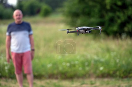 Téléchargez les photos : Drone copter avec appareil photo numérique volant dans les airs avec fond flou - en image libre de droit