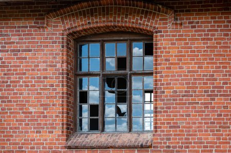 Téléchargez les photos : Une vieille fenêtre avec des vitres cassées dans un mur de briques rouges. Gros plan - en image libre de droit