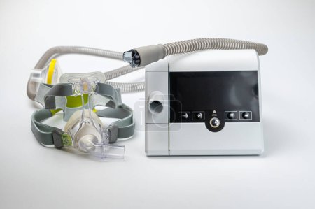 Foto de El sistema de presión positiva continua de las vías respiratorias incluye máquina CPAP, máscara, tubo sobre fondo blanco. - Imagen libre de derechos