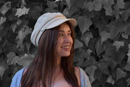 Téléchargez les photos : Belle jeune femme dans un chapeau et des lunettes de soleil posant dans la ville - en image libre de droit