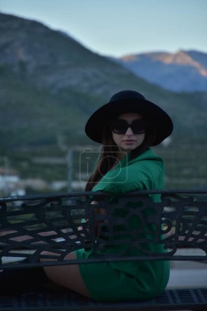 Téléchargez les photos : Jeune femme en chapeau et lunettes de soleil posant dans la forêt d'été sur la plage - en image libre de droit