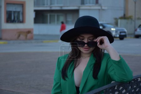 Téléchargez les photos : Belle jeune femme dans un chapeau et des lunettes de soleil dans la ville - en image libre de droit