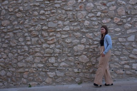 Téléchargez les photos : Belle jeune femme dans une robe sur le fond du vieux mur de briques - en image libre de droit