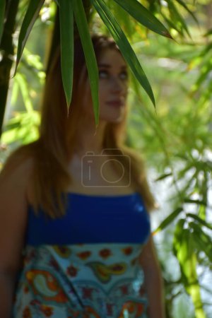 Téléchargez les photos : Belle jeune femme dans une robe d'été posant dans le parc - en image libre de droit