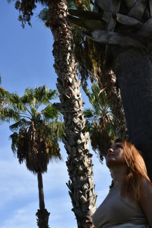 Téléchargez les photos : Beautiful young woman in park with palm trees - en image libre de droit