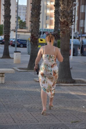 Téléchargez les photos : Belle jeune femme dans une robe dans la rue - en image libre de droit