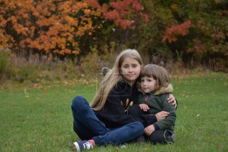 Photo for Two sisters in the fall on the lawn - Royalty Free Image