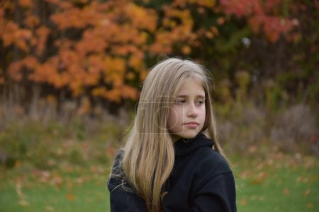 Photo for Beautiful young girl posing at camera in autumn park - Royalty Free Image