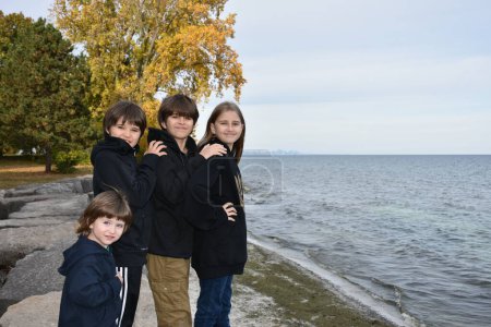 Photo for Happy family of four in autumn park, three children, boys and girls - Royalty Free Image