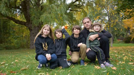 Photo for Happy family of four with four boys, and girl in autumn park - Royalty Free Image