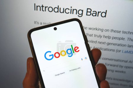 Photo for Google launches Bard AI. Google search bar on a phone in hand with release information on background. Google Bard AI vs OpenAI ChatGPT. Warsaw, Poland - February 8, 2023. - Royalty Free Image
